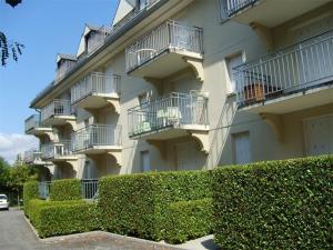um grande edifício com arbustos à frente em Appartement Bagnères-de-Luchon, 2 pièces, 4 personnes - FR-1-313-123 em Luchon
