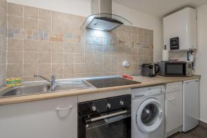 a kitchen with a sink and a washing machine at L'ISLE D'OR - LES AMANDIERS - 3 étoiles - 1er étage in LʼIsle-sur-la-Sorgue +19 photos