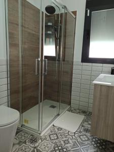 een douche met een glazen deur in een badkamer bij Angkor Wat Village in Puerto Real