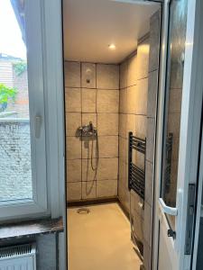 La salle de bains est pourvue d'une douche avec un pommeau de douche. dans l'établissement Proche de tout lieux touristiques à Liège, à Liège