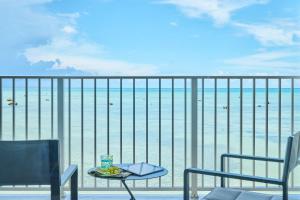 a balcony with a table and chairs and the ocean at Watermark Hotel Okinawa Miyakojima in Miyako Island