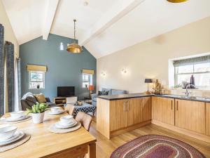 a living room with a table and a kitchen at Stables Cottage in Darlington