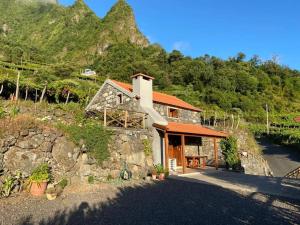 a stone house on a hill with a mountain at Zef's Cottage in São Vicente