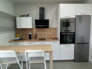 een keuken met een houten tafel en witte kasten bij Angkor Wat Village in Puerto Real