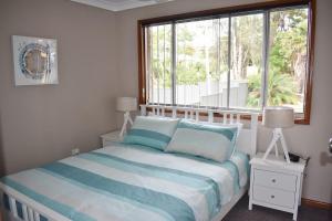 a bedroom with a bed and a large window at Little Fish in South West Rocks
