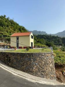 a house on a stone wall next to a road at Zef's chalet in Senhora do Rosário