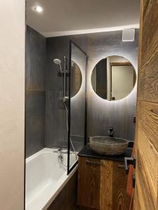 ein Badezimmer mit einer Badewanne, einem Waschbecken und einer Badewanne in der Unterkunft les jardins de val in Val dʼIsère