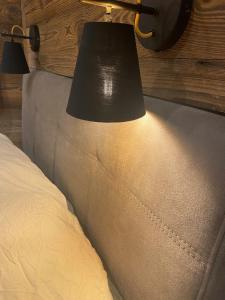 eine Lampe an der Seite eines Bettes mit einer Couch in der Unterkunft les jardins de val in Val dʼIsère