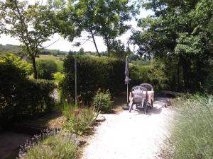 a patio with two chairs and an umbrella at La Petite Tour in Carlux