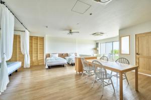 een woonkamer met een tafel en stoelen en een slaapkamer bij Watermark Hotel & Resorts Okinawa Miyakojima in Miyako Island