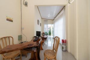 sala de estar con mesa de madera y sillas en RedDoorz near RS Awal Bros Sudirman Pekanbaru, en Parit