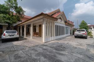 a house with a porch and a car parked in front at RedDoorz near RS Awal Bros Sudirman Pekanbaru in Parit