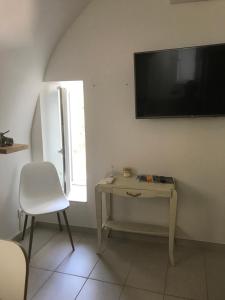 a room with a table and a television on a wall at Ma maisonnette in Allauch