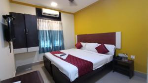 a bedroom with a bed and a television in it at Skyry Hotels Adyar in Chennai
