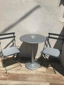 una mesa y dos sillas sentadas junto a una mesa en Ma maisonnette en Allauch