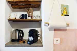 une cafetière sur une étagère dans un mur dans l'établissement Giourgas Cottage Milos Island, à Ralaki