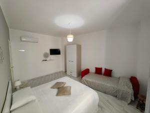 a white bedroom with a bed and a tv at Bed and Breakfast Champagne in Sanza