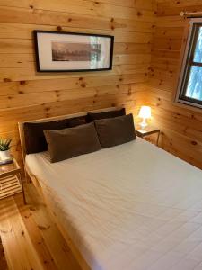 een slaapkamer met een wit bed in een houten muur bij Vila Paradise Bay in Smalvos