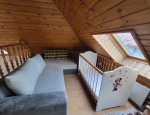 an attic room with a bed and a staircase at Dom Bystrá pod Chopkom & wellness in Bystrá