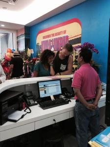 a group of people standing around a desk with a computer at YY48 Hotel 2 Mins Walk From Masjid Jamek LRT Station in Kuala Lumpur