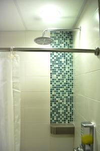 a bathroom with a shower with a tile wall at YY48 Hotel 2 Mins Walk From Masjid Jamek LRT Station in Kuala Lumpur