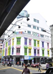 biały budynek z kolorowymi oknami na ulicy miejskiej w obiekcie YY48 Hotel 2 Mins Walk From Masjid Jamek LRT Station w Kuala Lumpur