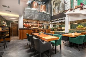 ein Restaurant mit Holztischen und grünen Stühlen in der Unterkunft Brovar 16 in Pless