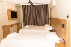 a hotel room with three beds and a window at Fidanoğlu Suite Hotel Çorlu in Corlu