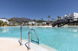 une grande piscine avec un escalier menant à celle-ci dans l'établissement Penthouse in exclusive resort, à Estepona