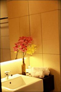 a bathroom sink with a pink flower in it at U Hotel Penang in Bayan Lepas