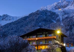 een hotel met een met sneeuw bedekte berg op de achtergrond bij Café Pension Alpina in Innsbruck