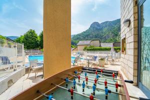 uma piscina com um monte de gente a jogar um jogo numa mesa em Village de gîtes de Blajoux em Quézac