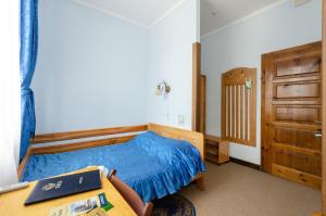 ein Schlafzimmer mit einem blauen Bett und einer Holztür in der Unterkunft Тиса Економ in Kiew