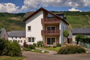 a white house with a balcony in a vineyard at Landhaus Wehlener Klosterberg in Bernkastel-Kues