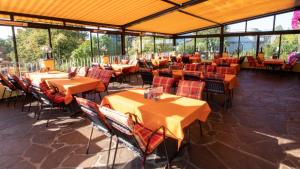 a restaurant with orange tables and chairs and windows at Café Pension Alpina in Innsbruck