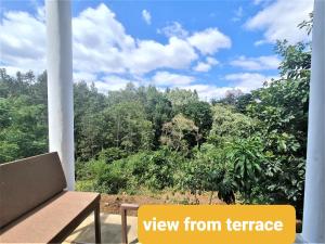 a view from a balcony with a view of trees at Holiday cottage by the river, Arusha in Arusha
