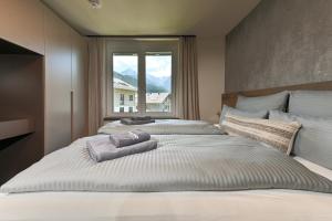 two beds in a bedroom with a large window at BergCrystal in Garmisch-Partenkirchen
