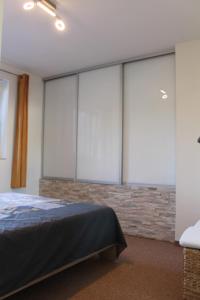 1 dormitorio con grandes ventanas de cristal y 1 cama en Au lit de l'Amblève, en Malmedy