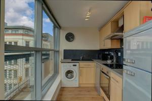 uma cozinha com uma máquina de lavar roupa e uma janela em * Stunning City Centre Penthouse Over Two Floors * em Manchester