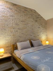 a bedroom with a bed with a brick wall at Park Hotel in Umanʼ