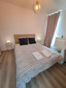 sypialnia z dużym łóżkiem z dwoma ręcznikami w obiekcie Le Manhattan 3*, Lumineux , calme vue sur le lac w mieście Bruges