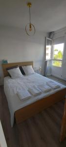 sypialnia z dużym łóżkiem z białą pościelą i oknem w obiekcie Le Manhattan 3*, Lumineux , calme vue sur le lac w mieście Bruges