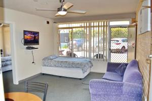 a living room with a bed and a couch at Wards Holiday Flat 3 in South West Rocks
