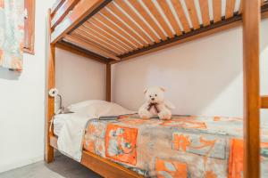 um urso de peluche sentado em cima de uma cama em Village de Gîtes de Chanac em Chanac