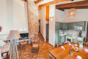 a kitchen with green cabinets and a wooden table at Village de Gîtes de Chanac in Chanac