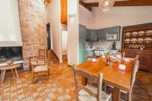 cocina y comedor con mesa de madera en Village de Gîtes de Chanac, en Chanac