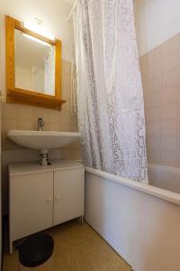 a bathroom with a sink and a shower curtain at Appartement Chabrières in Réallon
