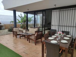 un patio con mesa, sillas y sofá en LUXURY VILLA Ocean Views, en Candelaria