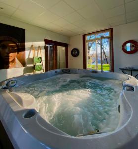 uma grande banheira de hidromassagem no meio de um quarto em Maison D'hôtes Sainte-Marie em Mirande