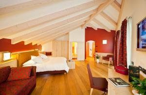 Revò的住宿－Viridis Hotel，一间卧室设有一张床和一间客厅。